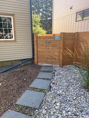 A wooden gate with a number, a gravel pathway, and a wooden fence. - Renovated Suite - Downtown Fernie - Pet Friendly (Fernie)