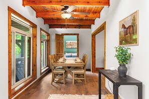 A dining area with a wooden table, chairs, and a ceiling fan. - BourbonTrl Luxe-15acres-GolfSim-HotTub-GameRm (Versailles)