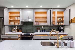 A modern kitchen with white cabinets, a stainless steel range, and a built-in oven. - BourbonTrl Luxe-15acres-GolfSim-HotTub-GameRm (Versailles)