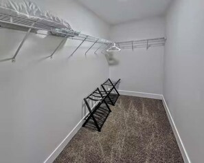 A small, carpeted room with a built-in metal drying rack and a separate rack against the wall. - Vegas Group Getaway | Private Pool & Grill (Las Vegas)
