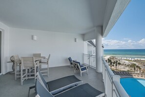 A balcony with a table and chairs, a pool, and a view of the beach and ocean. - Gulf View Ocean Front Condo, Balconies, 2 Pools, Hot tub, Sauna, Gym, Full Kitchen, Washer and Dryer (Santa Rosa Beach)