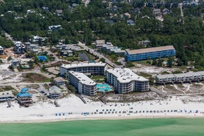 An aerial view of a coastal resort with multiple buildings, a beach, and a swimming pool complex. - Gulf View Ocean Front Condo, Balconies, 2 Pools, Hot tub, Sauna, Gym, Full Kitchen, Washer and Dryer (Santa Rosa Beach)