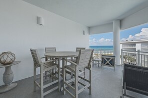 A balcony with a table and chairs, a decorative vase, and a view of the ocean. - Gulf View Ocean Front Condo, Balconies, 2 Pools, Hot tub, Sauna, Gym, Full Kitchen, Washer and Dryer (Santa Rosa Beach)