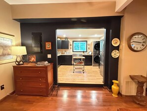 Una cocina moderna con armarios negros, encimera de madera y horno empotrado.