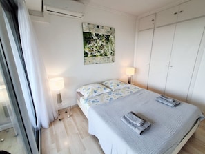 Una camera da letto con un letto, due lampade da comodino, un quadro appeso e un armadio.