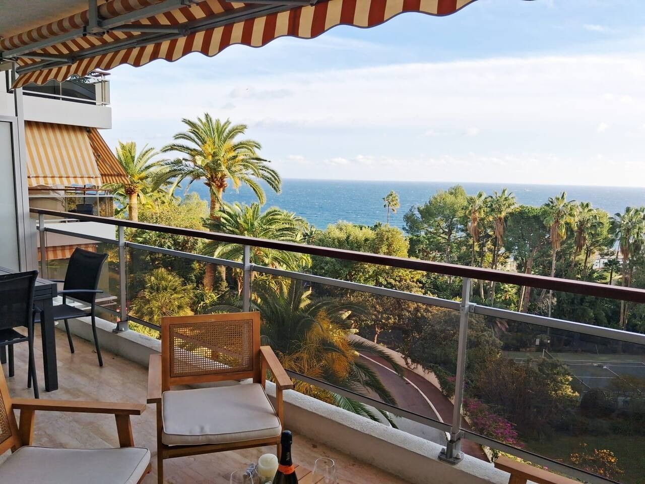 Un balcone con vista sul mare, dotato di tavolo e sedie.