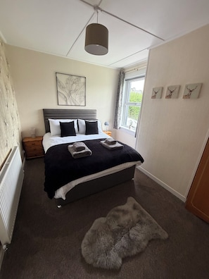 A bedroom with a bed, a window, a radiator, and a rug. - Kenmore is a lovely 3-bedroom house in Portree perfect for your getaway (Portree)