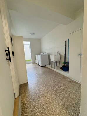 A laundry room with a washing machine, dryer, sink, and broom. - Centrally located in historic town of San Germán! (San Germán)