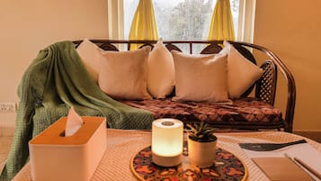 Una habitación acogedora con cama, mesita de noche con un pañero, lámpara y un plato decorativo.