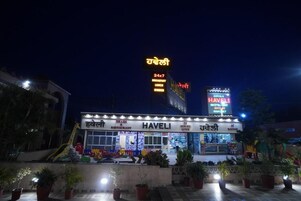A hotel named HAVELI with a sign indicating 24x7 service hours.