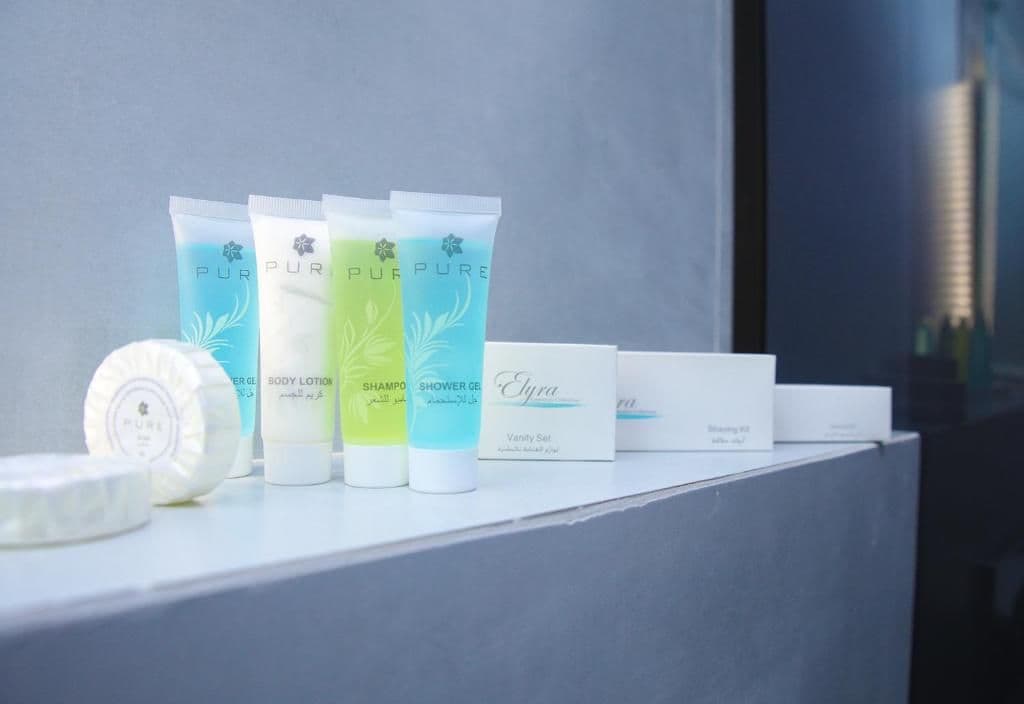 A selection of body care products including body lotion, shampoo, and shower gel, arranged on a shelf.