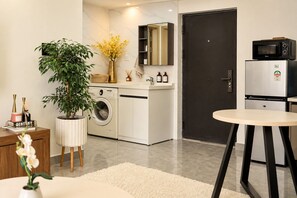 A modern kitchen with a washing machine, a microwave, and a refrigerator. - Westlands 1 bedroom apartment with gym,pool and rooftop restaurant (Nairobi)