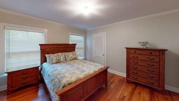 Un dormitorio con una cama de madera, un tocador y una mesita de noche.