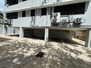A building with a flat roof, multiple air conditioning units, and a concrete floor with a drain. - Central San Germán - Private Patio / Generator (San Germán)