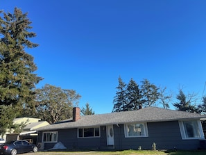 A residential house with a garage, a car parked in front, and a clear blue sky.