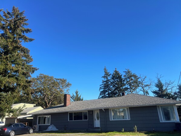 A residential house with a garage, a car parked in front, and a clear blue sky. - Tacoma GL (Tacoma)