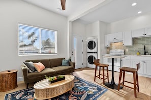 A modern apartment with a living room, kitchen, and laundry area. - Central Spot | 4 Min to Waterpark, Dining & Shops (Vista)