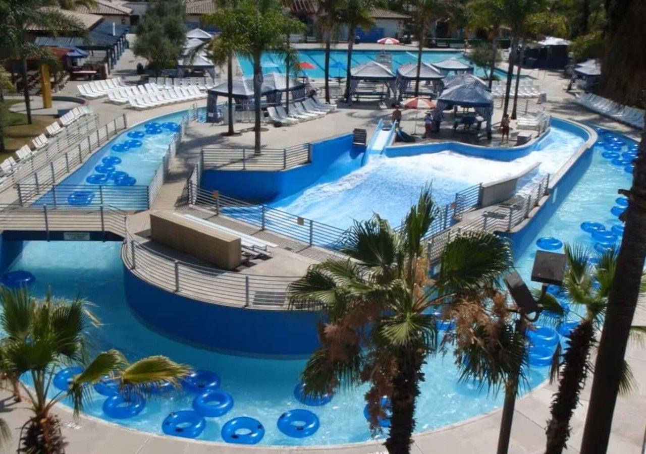 A water park with multiple pools, slides, and lounge areas.
