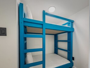 A bunk bed with a white mattress and a blue frame. - Modern Oceanfront Escape at Yachtsman! S900 (Myrtle Beach)