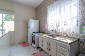 A kitchen with a refrigerator, stove, sink, and cabinets. - Private Pool House in California (Cabo Frio)