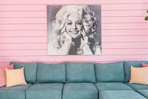 A teal sofa with pink cushions against a pink wall with horizontal lines. - The Jolene Bubbly Bar with Views 5min to DT (Nashville)