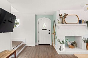Ein modernes Interieur mit einer weißen Tür, einem Kamin und einem an der Wand befestigten Fernseher.
