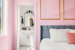 Une chambre à coucher avec un lit, une table de chevet, une commode et un miroir.