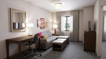 A hotel room with a desk, a sofa, a TV, and a cabinet.