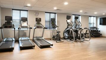 A gym with treadmills, elliptical machines, and a stationary bike.