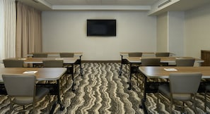 A conference room with a flat-screen TV, multiple tables, and chairs arranged for meetings. - ADA 1BR Suite w/ Free Breakfast + Local Shuttle (Vero Beach)