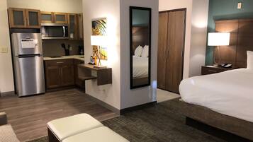Une chambre d’hôtel comprenant un lit, un bureau, une kitchenette et une salle de bain.