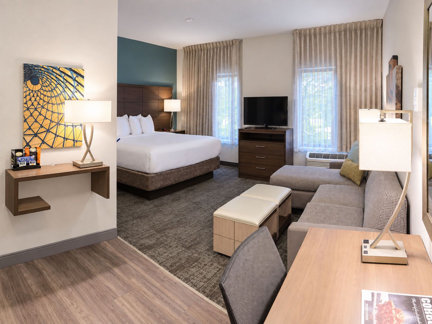 Une chambre d’hôtel avec un lit, une télévision, un bureau et un canapé.