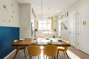 A modern kitchen with a central island, white cabinets, and a blue accent wall. - ~PrivateFencedYard|2FamilyRms|ParkNear|BlueBeauty (Calgary)