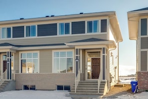 A two-story residential building with a brick facade, large windows, and a front entrance with steps. - ~PrivateFencedYard|2FamilyRms|ParkNear|BlueBeauty (Calgary)