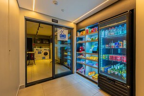 Une chambre d’hôtel équipée d’un lave-linge, d’un minibar et d’un réfrigérateur rempli de boissons.