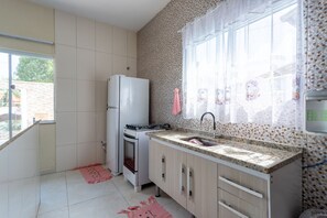 A kitchen with a refrigerator, stove, sink, and cabinets. - Casa com Piscina Privativa no Calif Rnia (Cabo Frio)