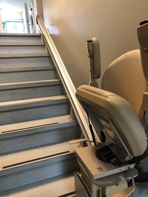 Un escalier avec une rampe et un fauteuil d’examen médical.