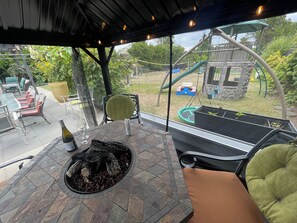 An outdoor patio with a fire feature, seating, and a view of a playground. - 5 Star 5 Bedroom Delta Home (Clean/Pet Friendly) Min 30 Days + 30% Discount (Delta)