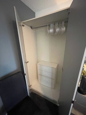 Ein begehbarer Kleiderschrank mit integriertem Stauraum und Kleiderstange.