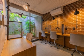 Un espace de bureau moderne avec un bureau en bois, des chaises de bureau et un mur en briques.