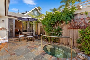 A backyard with a hot tub, patio furniture, and a wooden fence. - Escape to Casita at East Beach! (Santa Barbara)