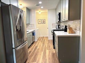 Una cocina moderna con electrodomésticos de acero inoxidable, microondas y estufa.