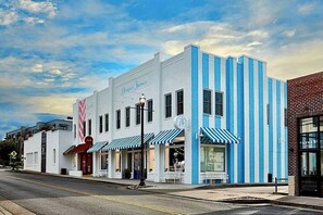 A two-story building with a white facade and blue-striped awnings, featuring a prominent 'Drapes & Frames' sign. - Home with Rooftop Patio + Garage, by 12 South and 2 miles to Broadway (Nashville)