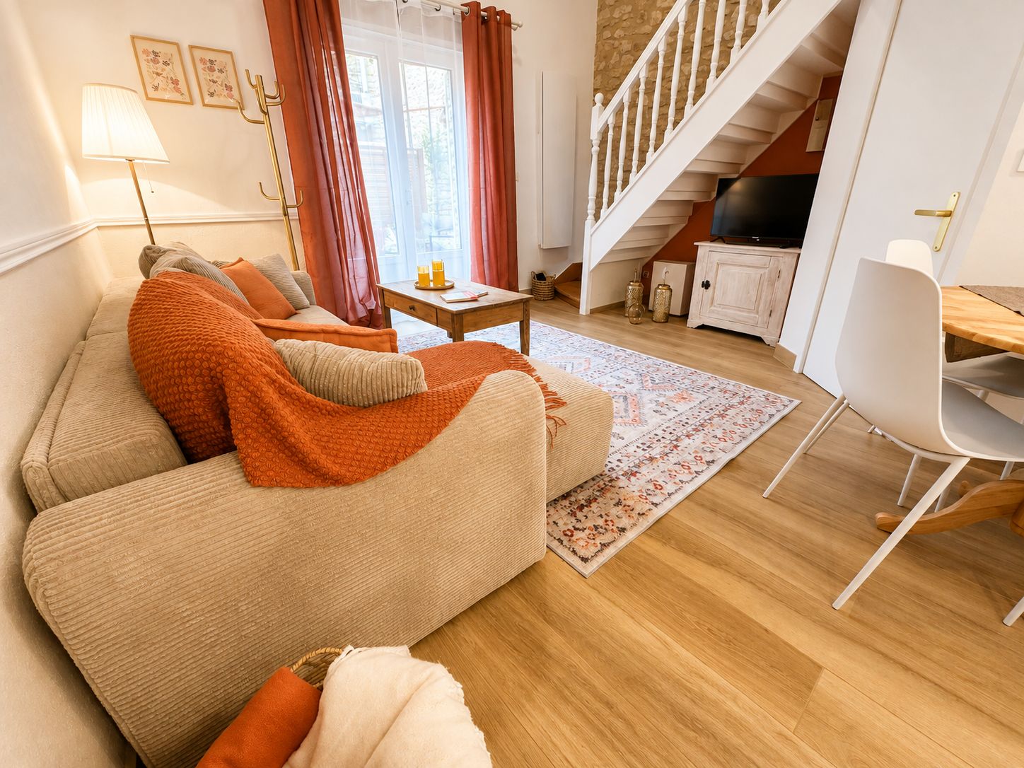 A cozy living room with a sofa, a coffee table, and a dining area with a chair.