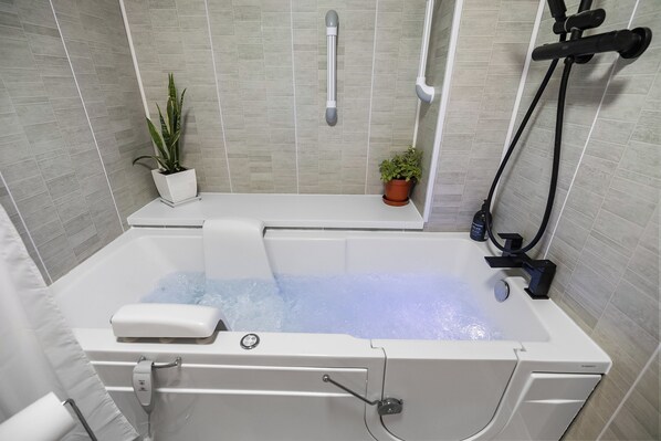 Ein modernes Badezimmer mit einer Badewanne, einer Duschkabine und einem Blumentopf.