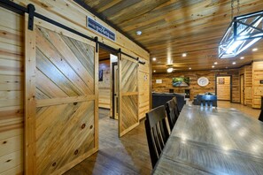 Dramatic barn doors frame the dining space where your best vacation meals happen. - A Beautiful View · New Listing! Ridgetop 5BR w/ Hot Tub, Game Room & Fire Pit (Broken Bow)