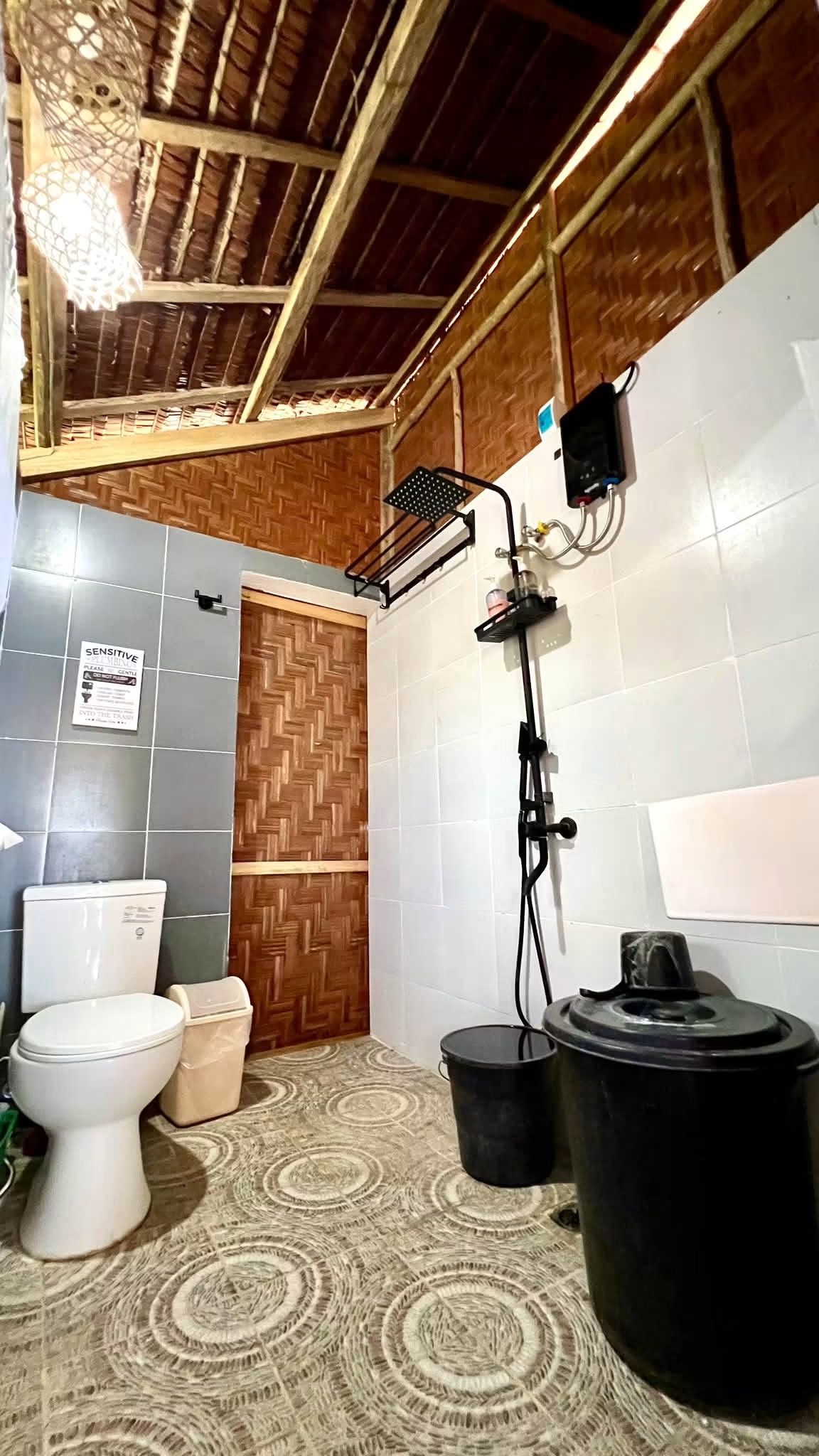 Een badkamer met toilet, hygiëneschuimer en douche.