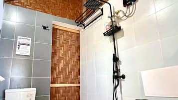 Een badkamer met toilet, hygiëneschuimer en douche.