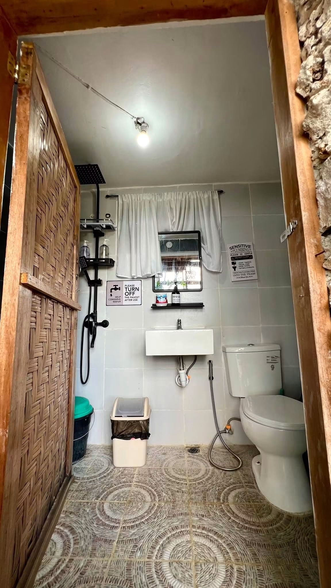Une petite salle de bain comprenant une douche, des toilettes et un lavabo.