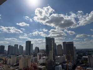 Eine Skyline mit Hochhäusern, blauem Himmel und Sonnenschein.